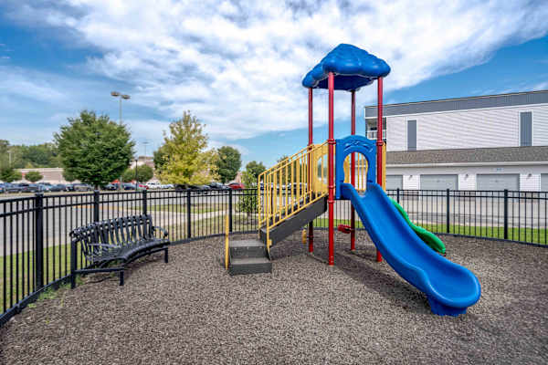 A playground with a blue slide and a yellow and red structure.